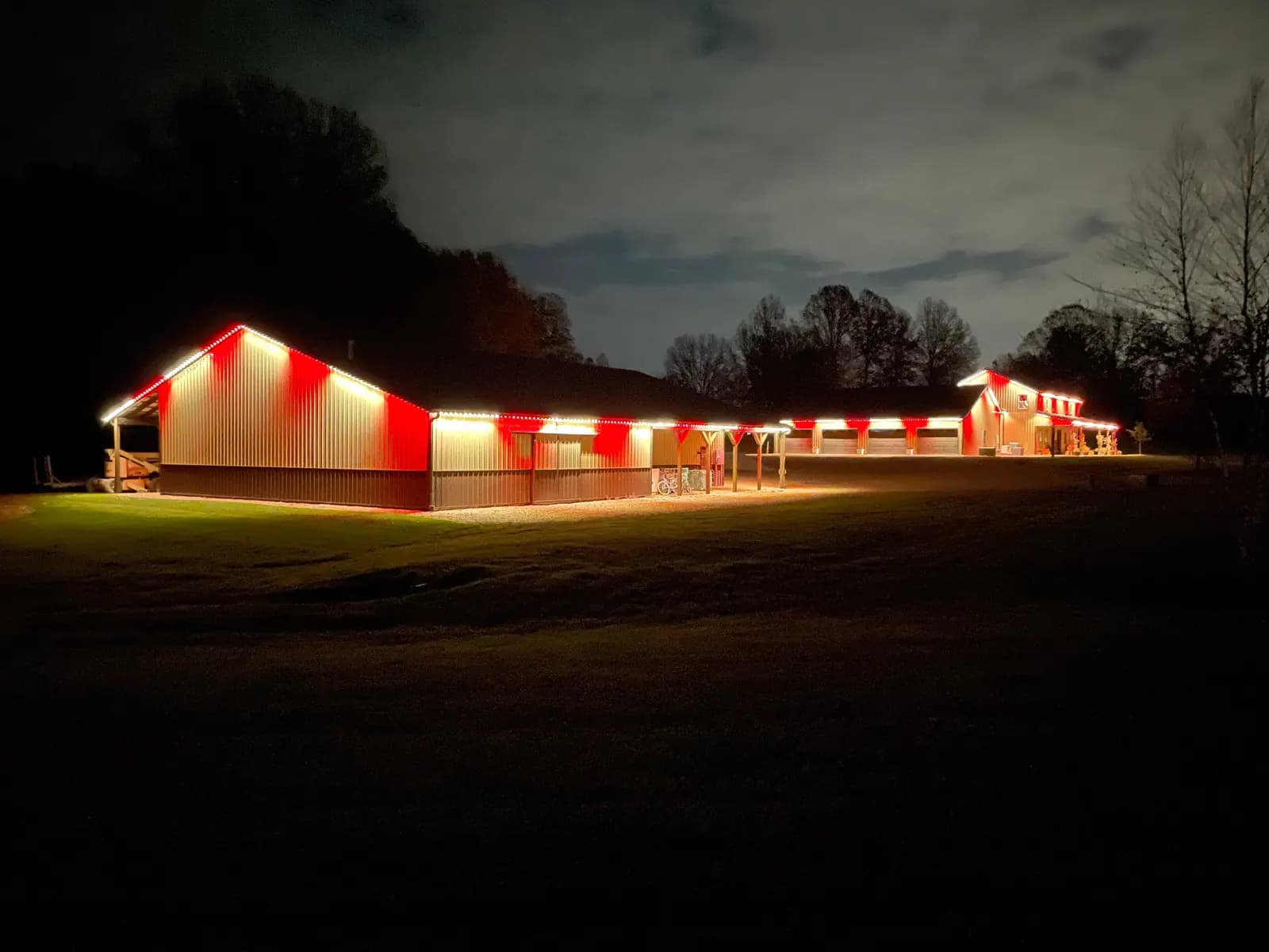 Steel-clad commercial building and shop outlined in red and white permanent LED lights at night - commercial permanent lighting
